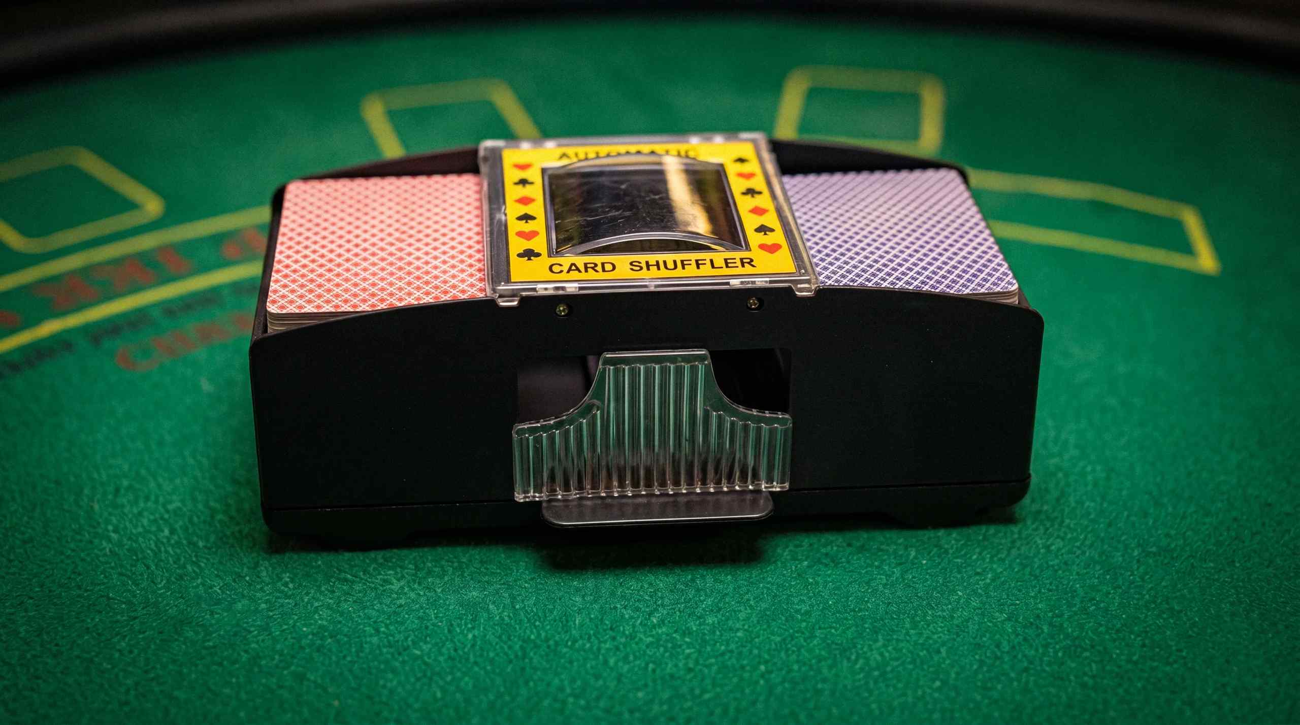 An automatic shuffler sitting on a felt table.